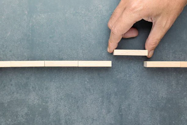 A hand placing the last block to complete a line of blocks