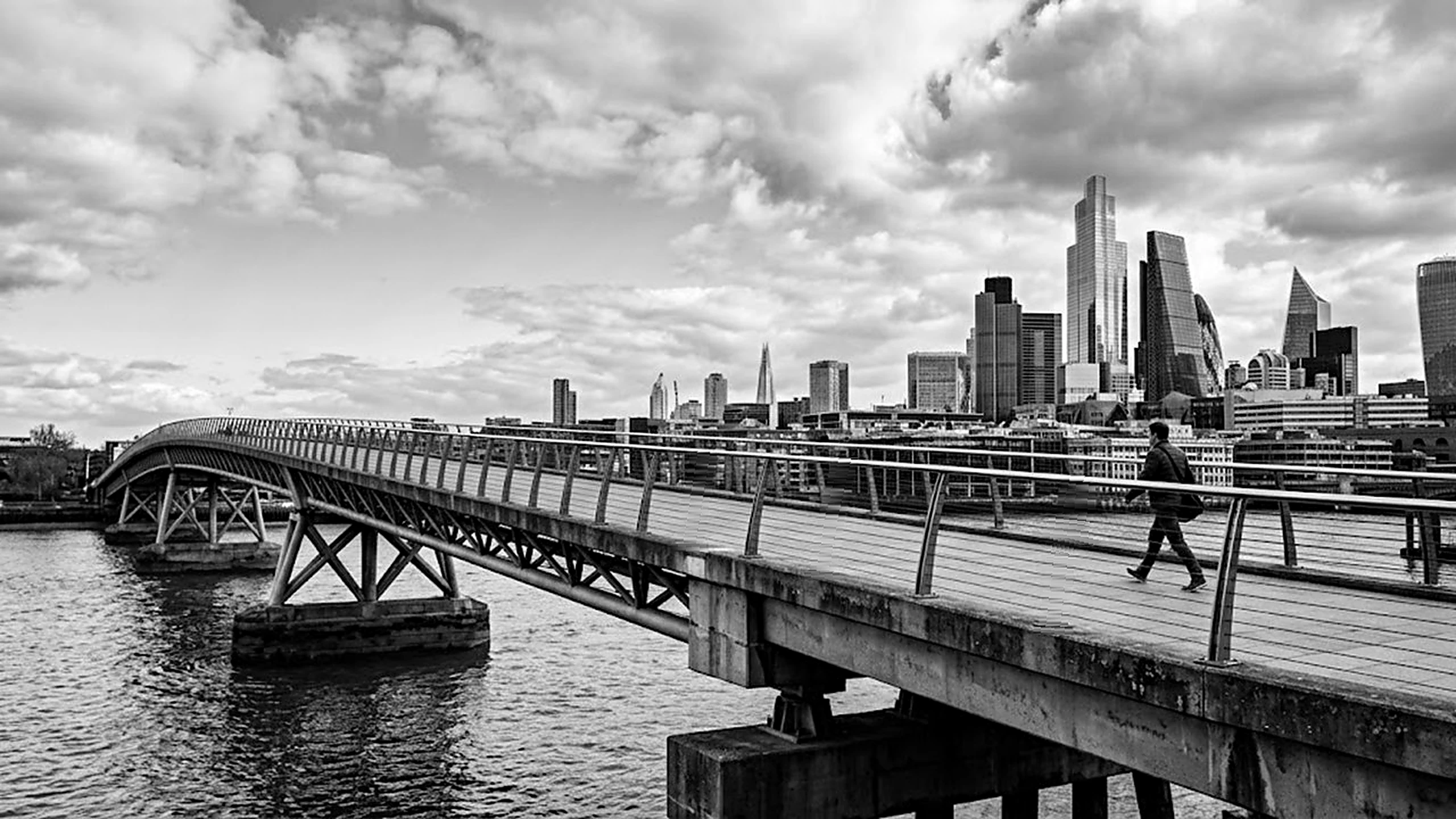 A footbridge leading towards a city skyline