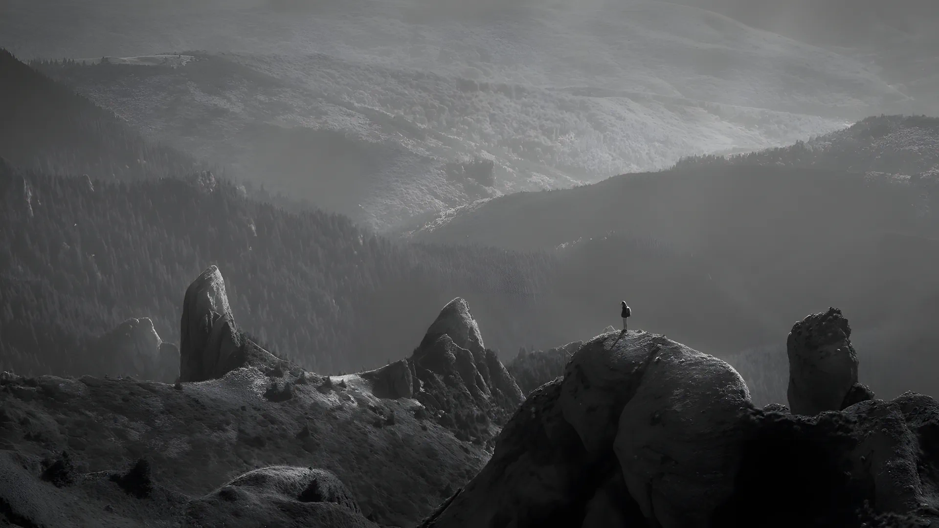 A lone figure on a rocky ridge above a valley
